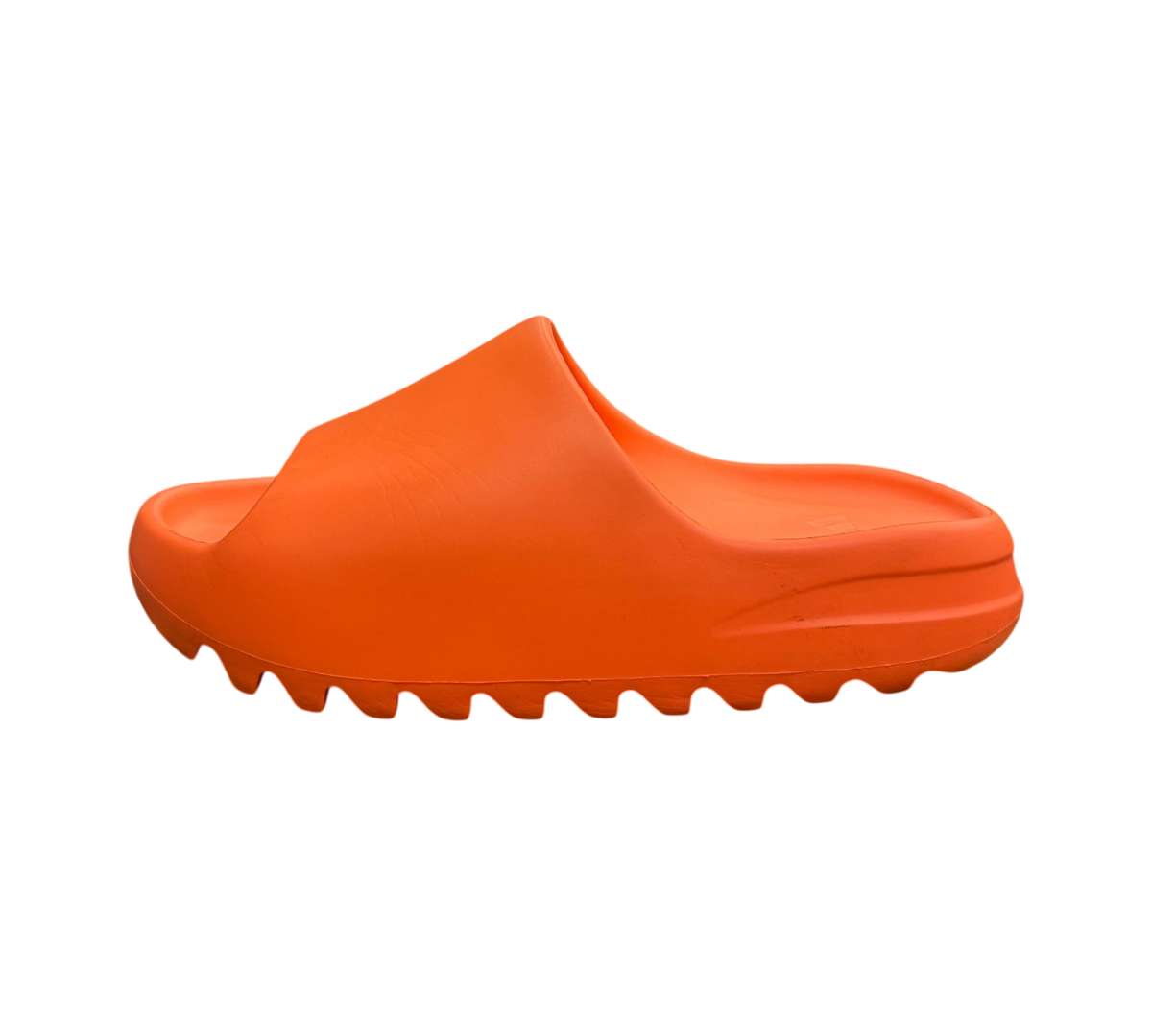 Genesis Boutique Yeezy Slide Enflame Orange in bright orange foam with a serrated outsole, side view on a shoe box.