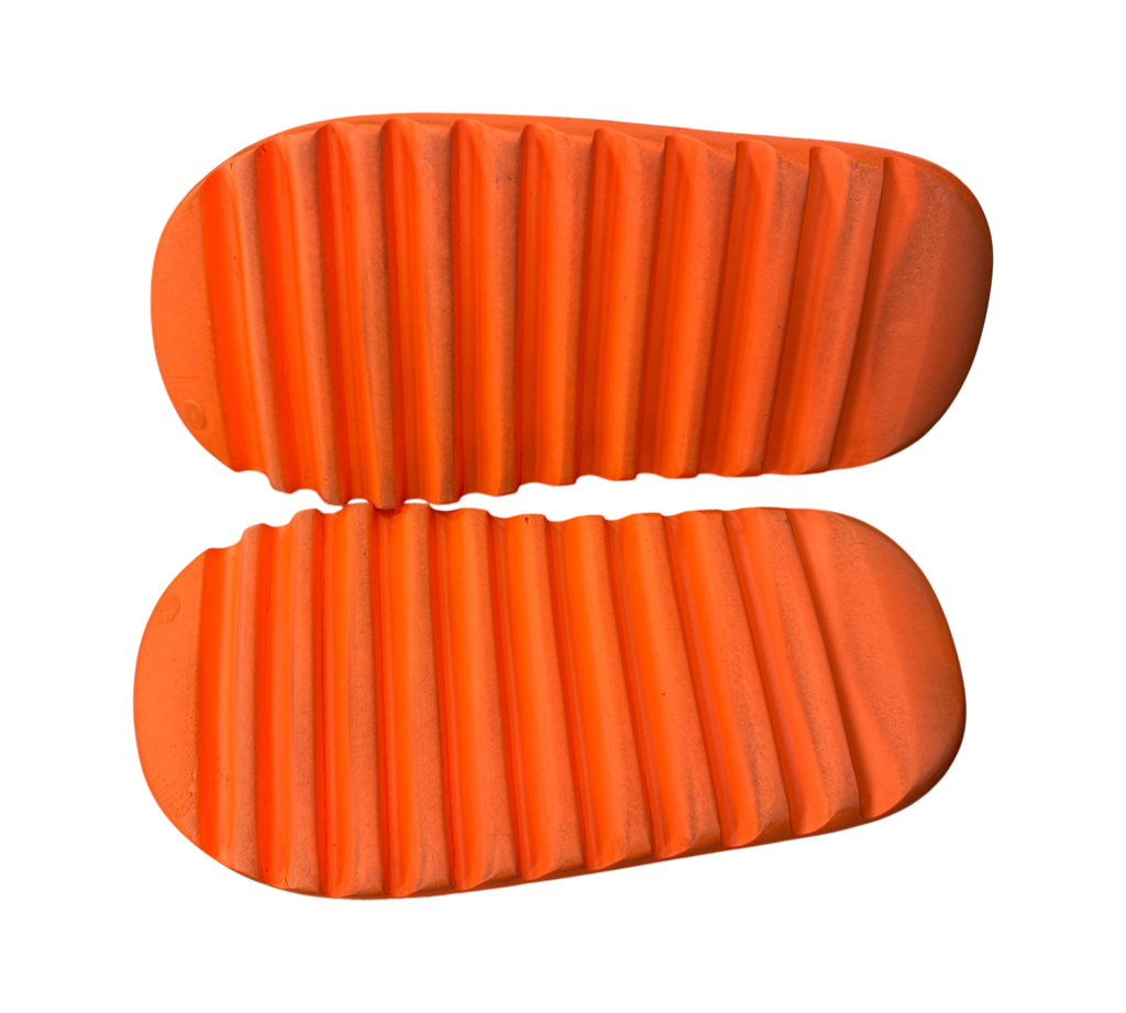 Genesis Boutique Yeezy Slide Enflame Orange showing the textured rubber outsoles of the used footwear