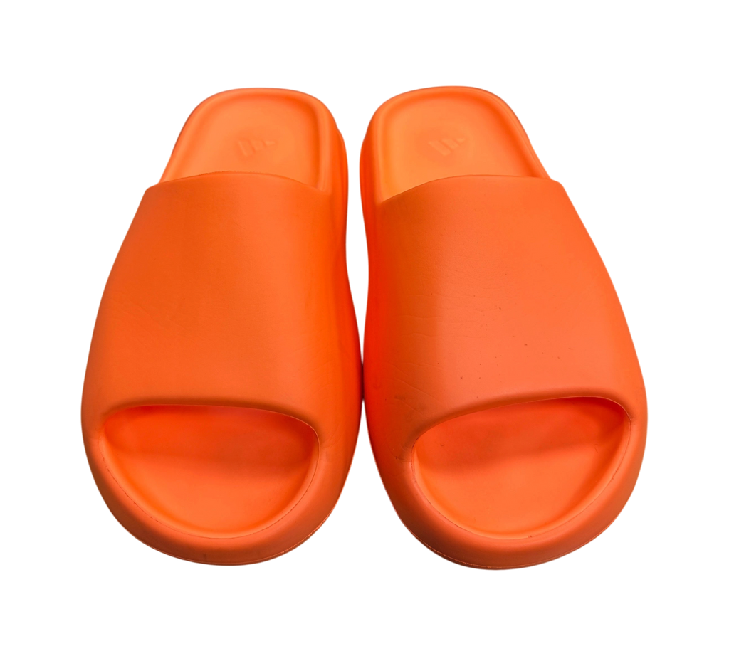 Genesis Boutique Yeezy Slide Enflame Orange foam sandals in vibrant orange, shown from a top-down view on a box.
