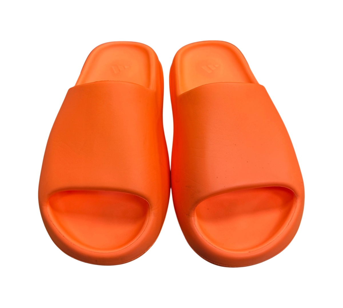 Genesis Boutique Yeezy Slide Enflame Orange foam sandals in vibrant orange, shown from a top-down view on a box.