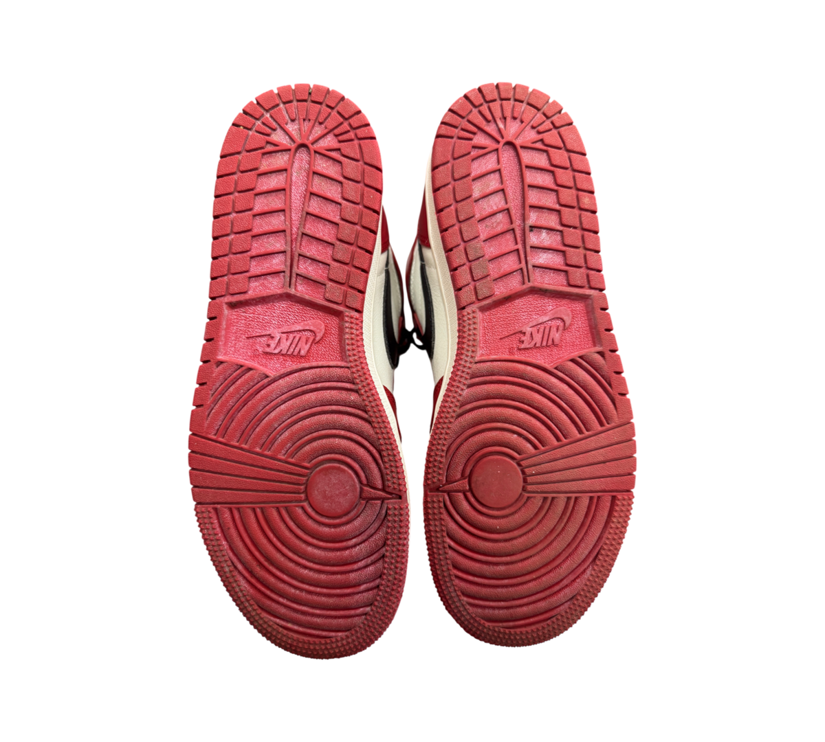 Genesis Boutique Jordan 1 GS Lost and Found sneakers showing red rubber outsoles with circular traction patterns