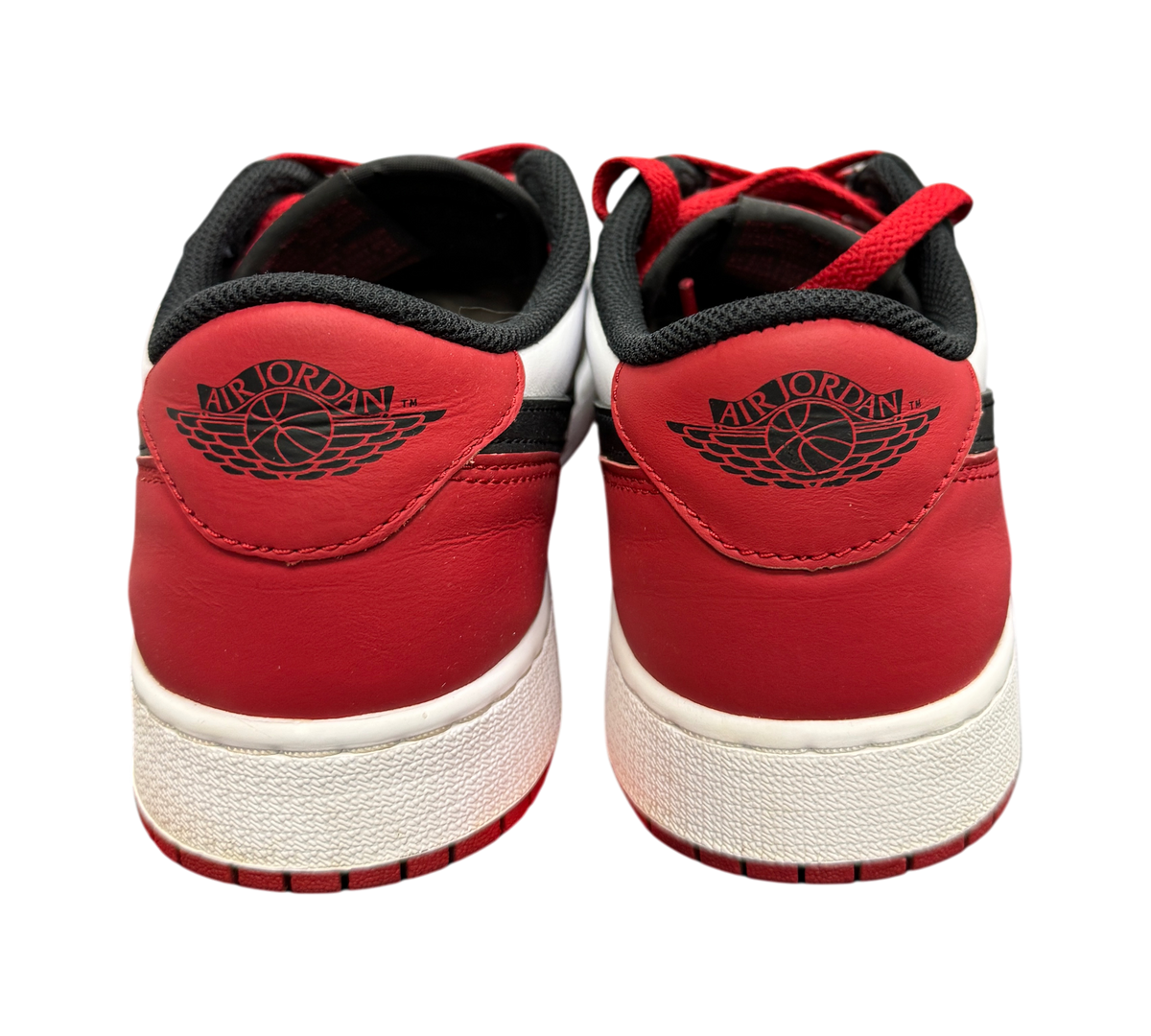 Genesis Boutique Jordan 1 Low Black Toe sneakers showing the red leather heel and black Air Jordan wings logo