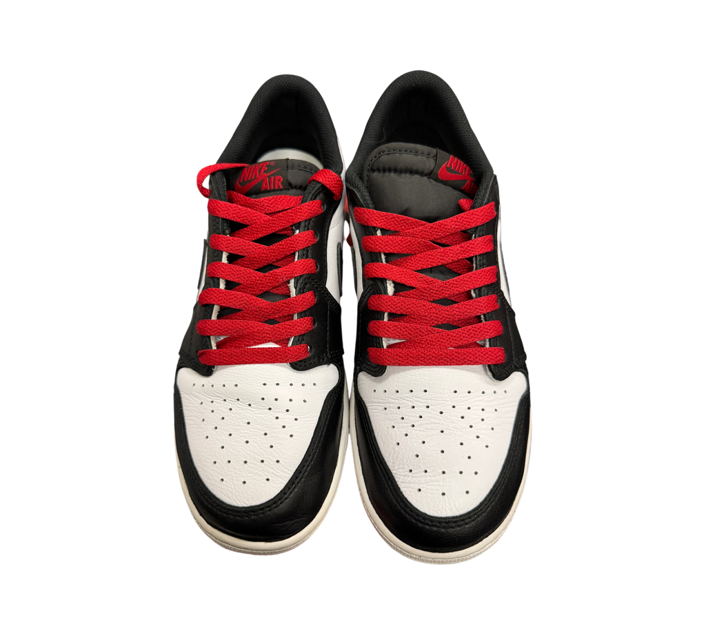 Genesis Boutique Jordan 1 Low Black Toe sneakers featuring white leather, black overlays, and vibrant red laces.