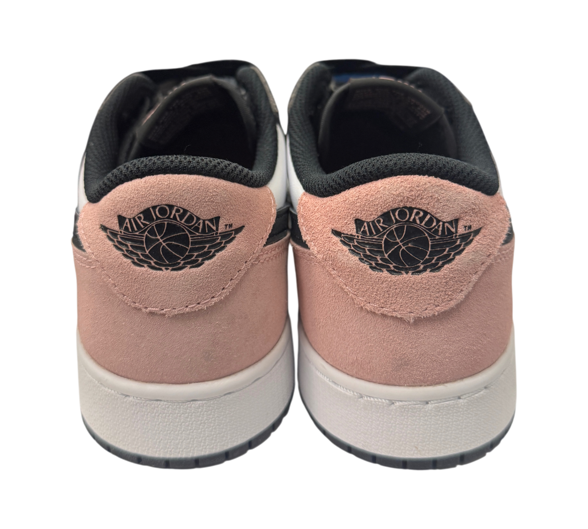 Genesis Boutique Jordan 1 Low Bleached Coral sneakers showing the pink suede heel and black Air Jordan wings logo