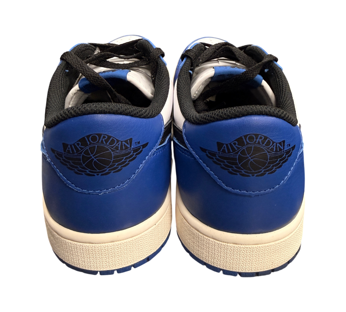 Genesis Boutique Jordan 1 Low Game Royal sneakers with white and blue leather, black laces, and Air Jordan wings logo.