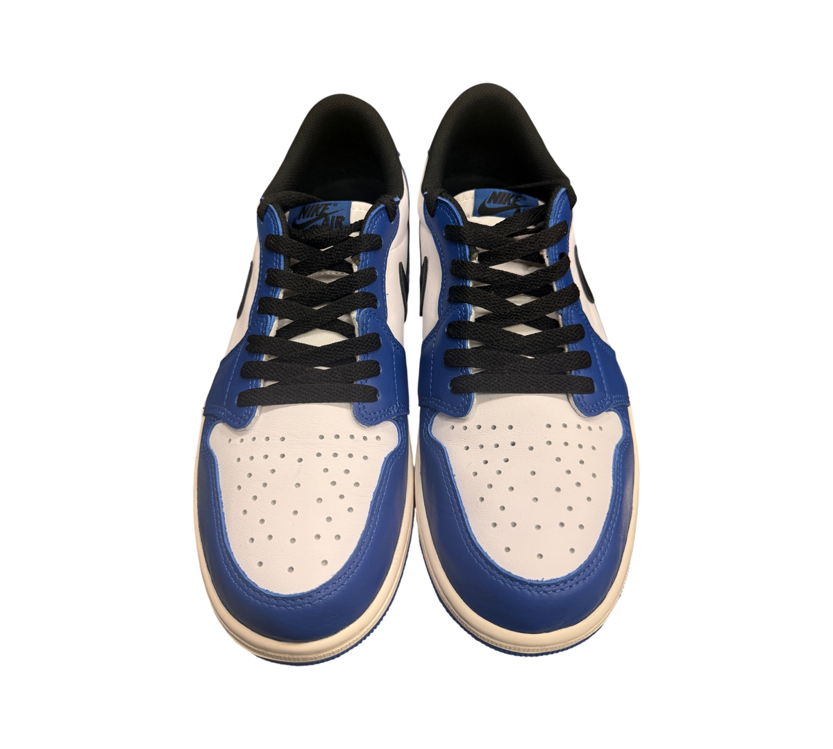 Genesis Boutique Jordan 1 Low Game Royal sneakers with white leather, blue overlays, and black laces.
