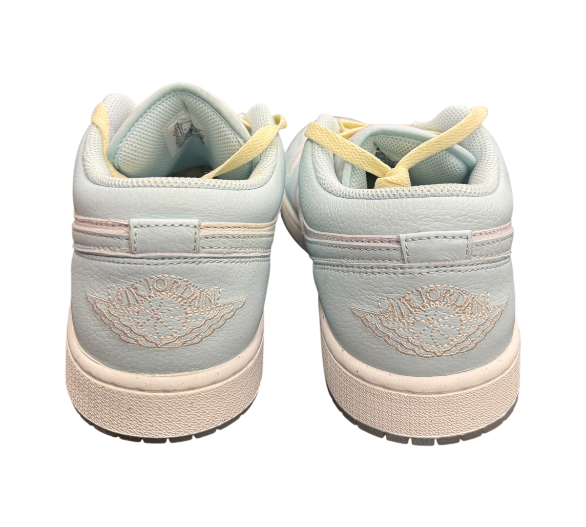 Genesis Boutique Jordan 1 Low Glacier Summit White sneakers featuring light blue leather and embroidered heel logos.