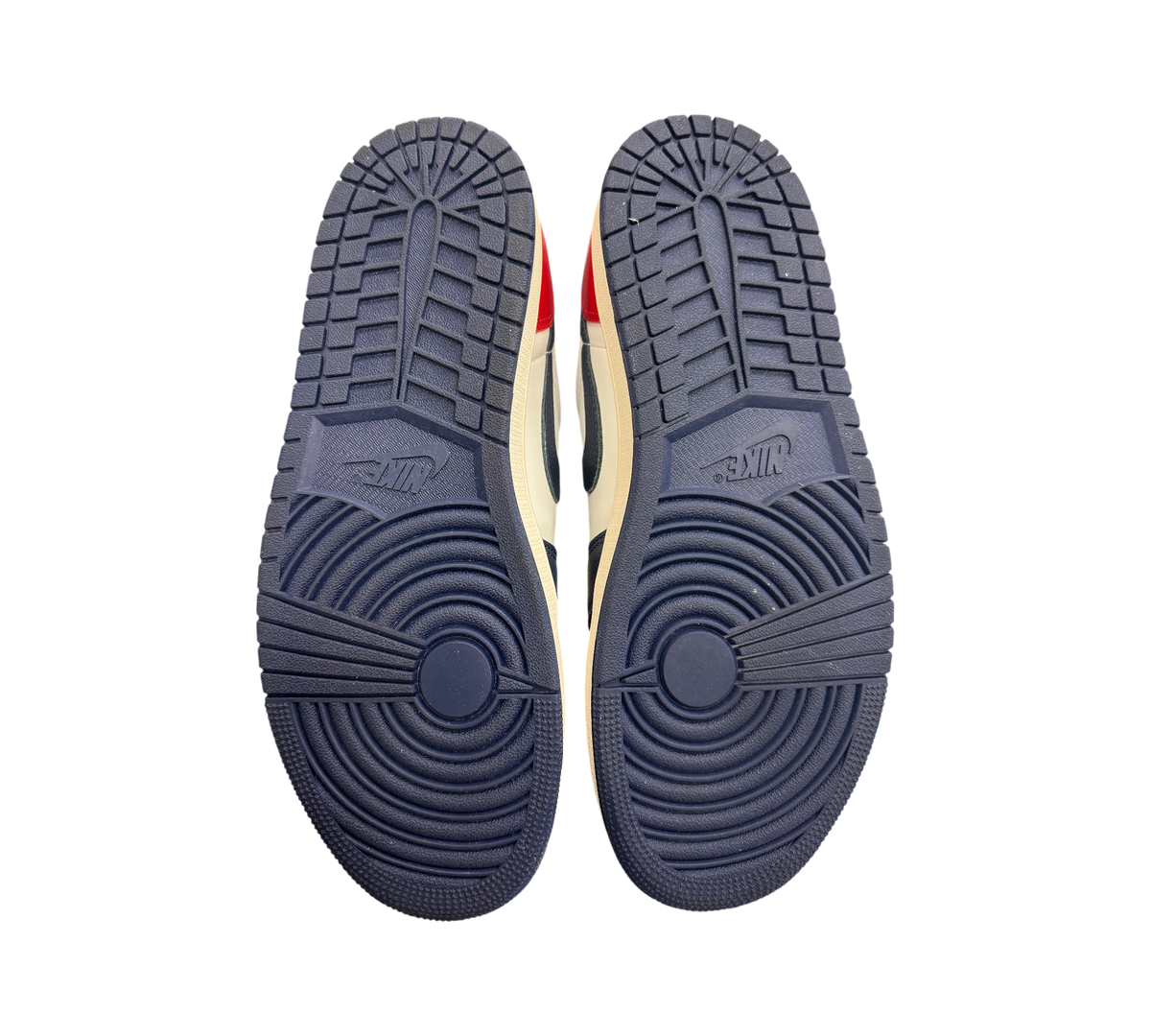 Genesis Boutique Jordan 1 Low Howard Uni sneakers showing the navy blue rubber outsoles with circular tread patterns.