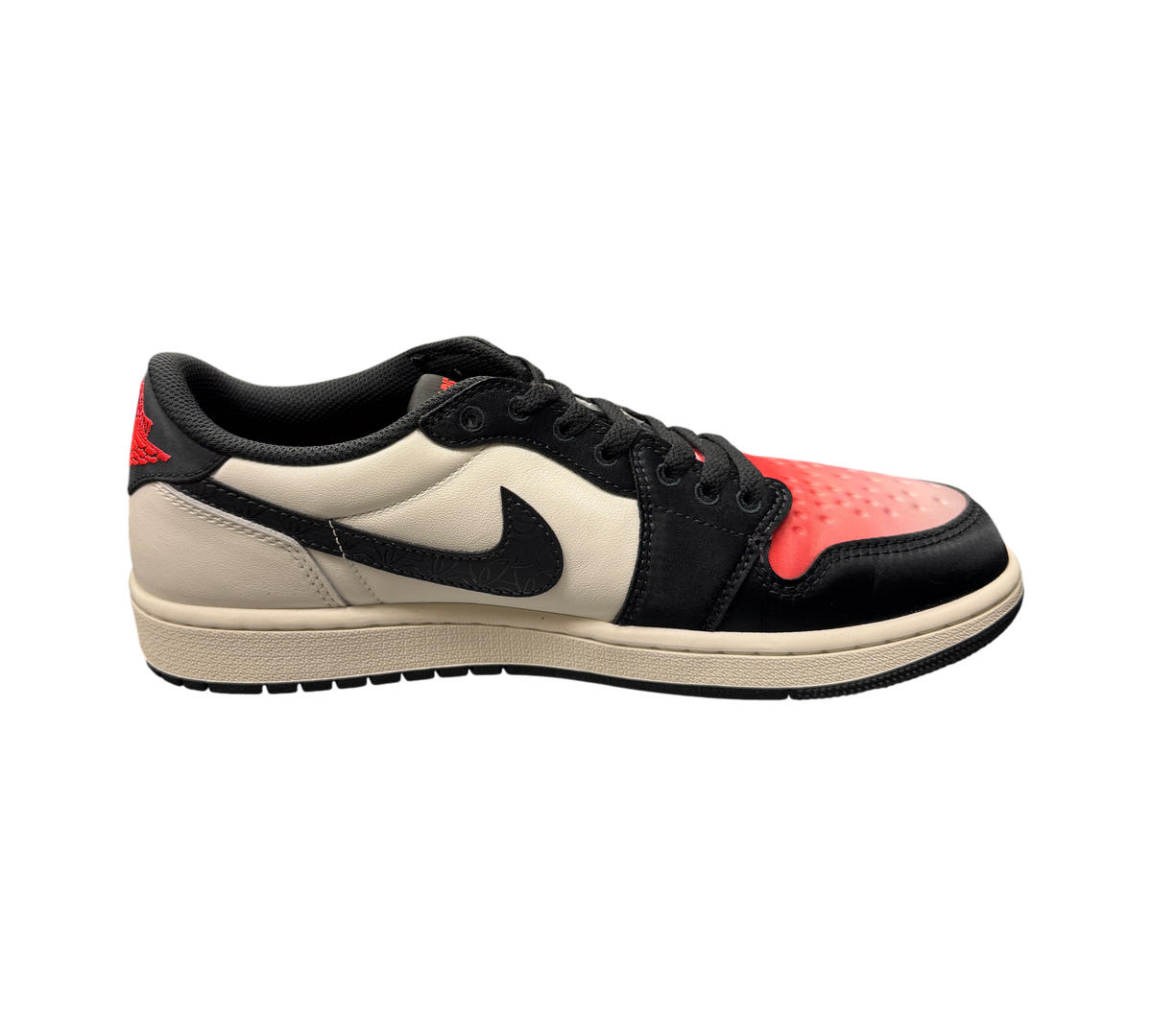 Genesis Boutique Jordan 1 Low PSG sneakers in white, black, and red with patterned swoosh on a glass display table.