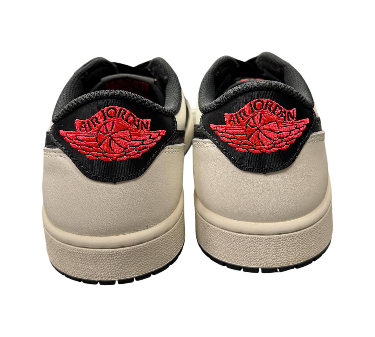 Heels of used Jordan 1 Low PSG sneakers at Genesis Boutique, featuring off-white leather and red Air Jordan branding.