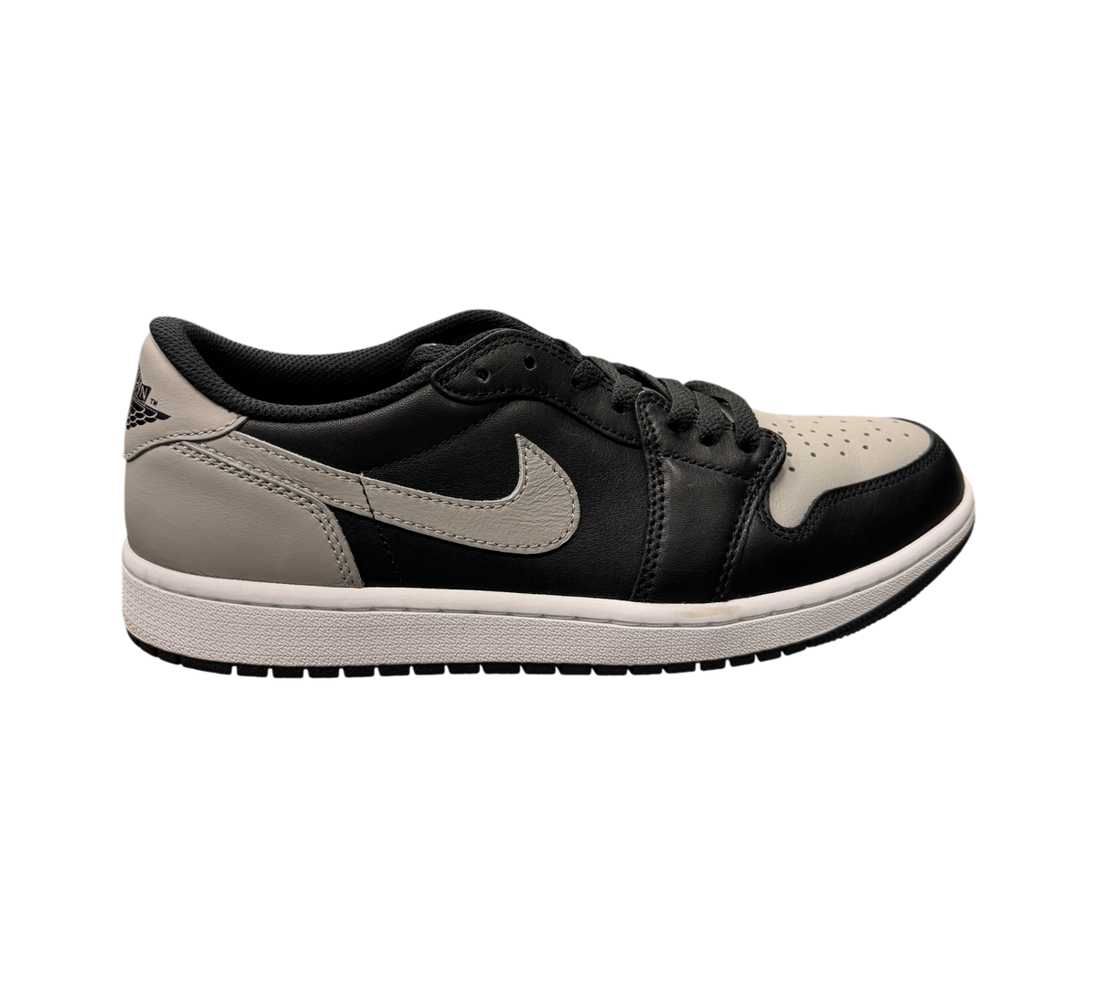 Genesis Boutique pre-owned Jordan 1 Low Shadow sneakers in black and grey leather on a glass display counter.