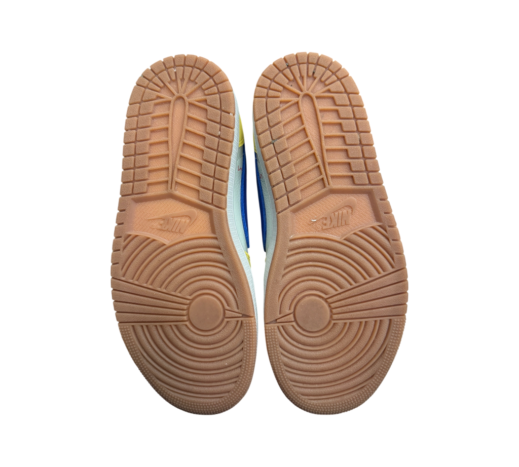 Genesis Boutique Jordan 1 Low Travis Scott Canary sneakers showing the gum rubber outsoles from a bottom view