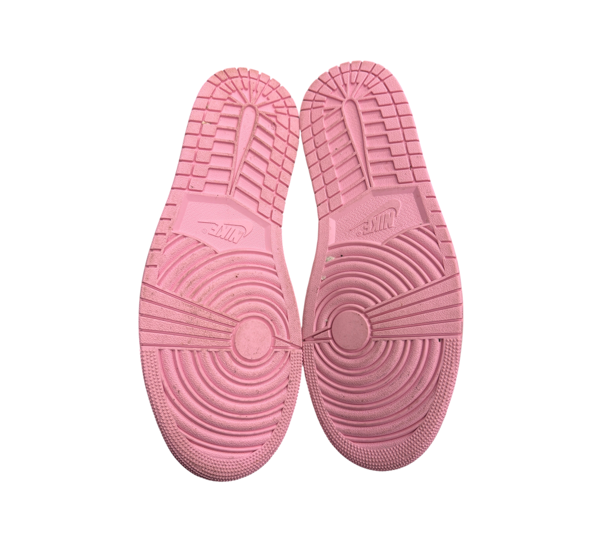 Genesis Boutique Jordan 1 Low Travis Scott Tropical Pink sneakers showing the pink rubber outsoles with Nike branding