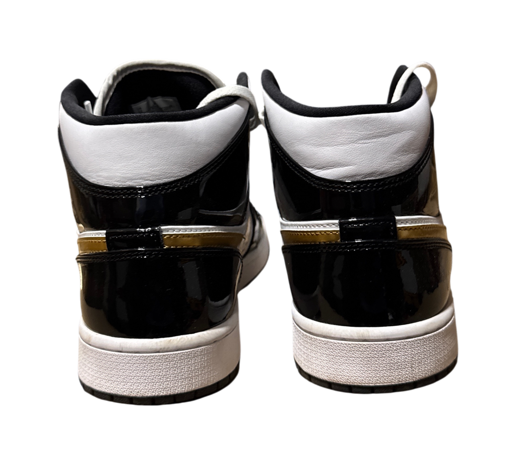 Genesis Boutique used Jordan 1 Mid Metallic Gold sneakers showing the black and white patent leather heel view