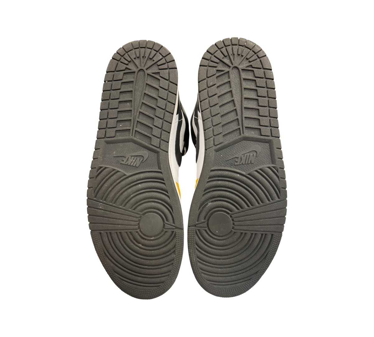 Genesis Boutique used Jordan 1 Mid Yellow Ochre sneakers showing black rubber outsoles with circular traction patterns