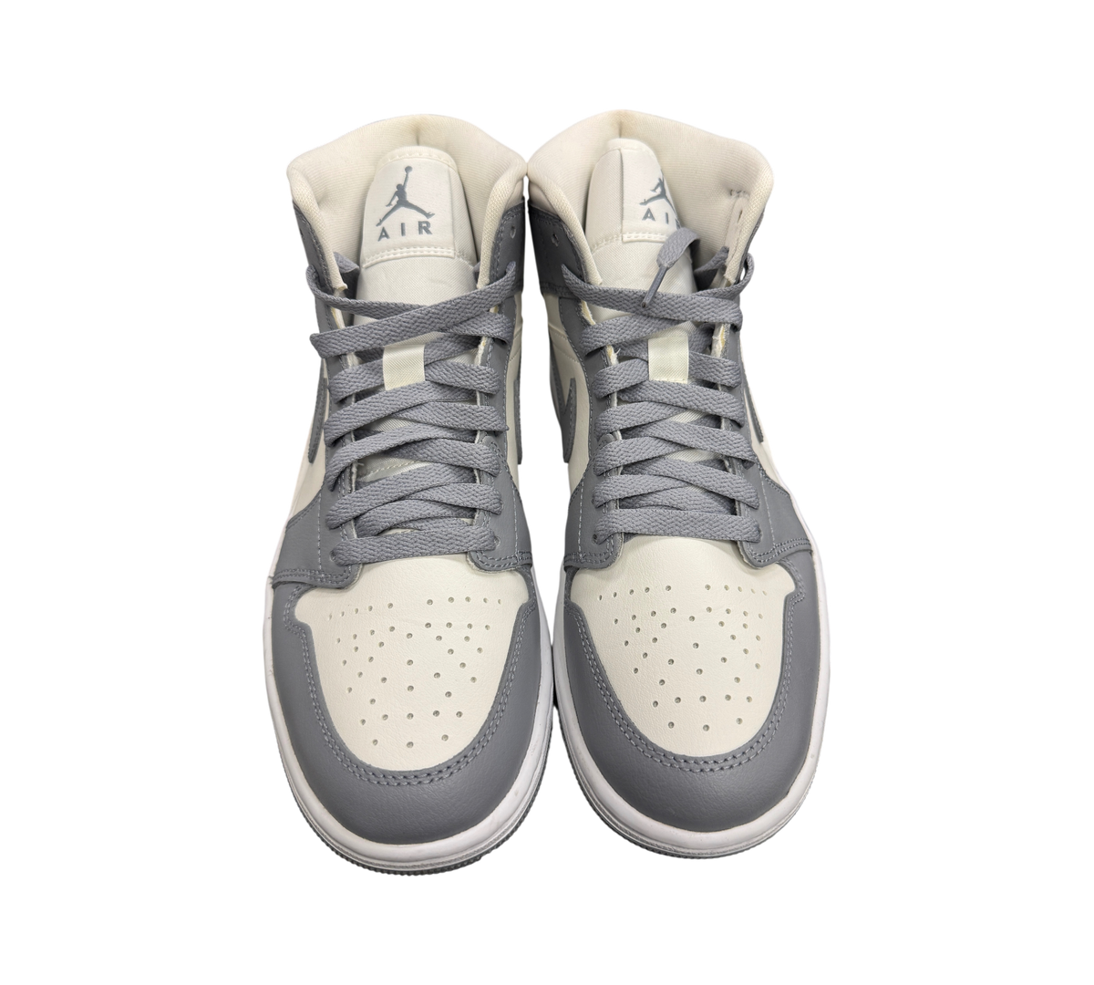 Genesis Boutique Jordan 1 Mid Stealth sneakers in grey and white leather with lace-up closure and Jumpman branding.