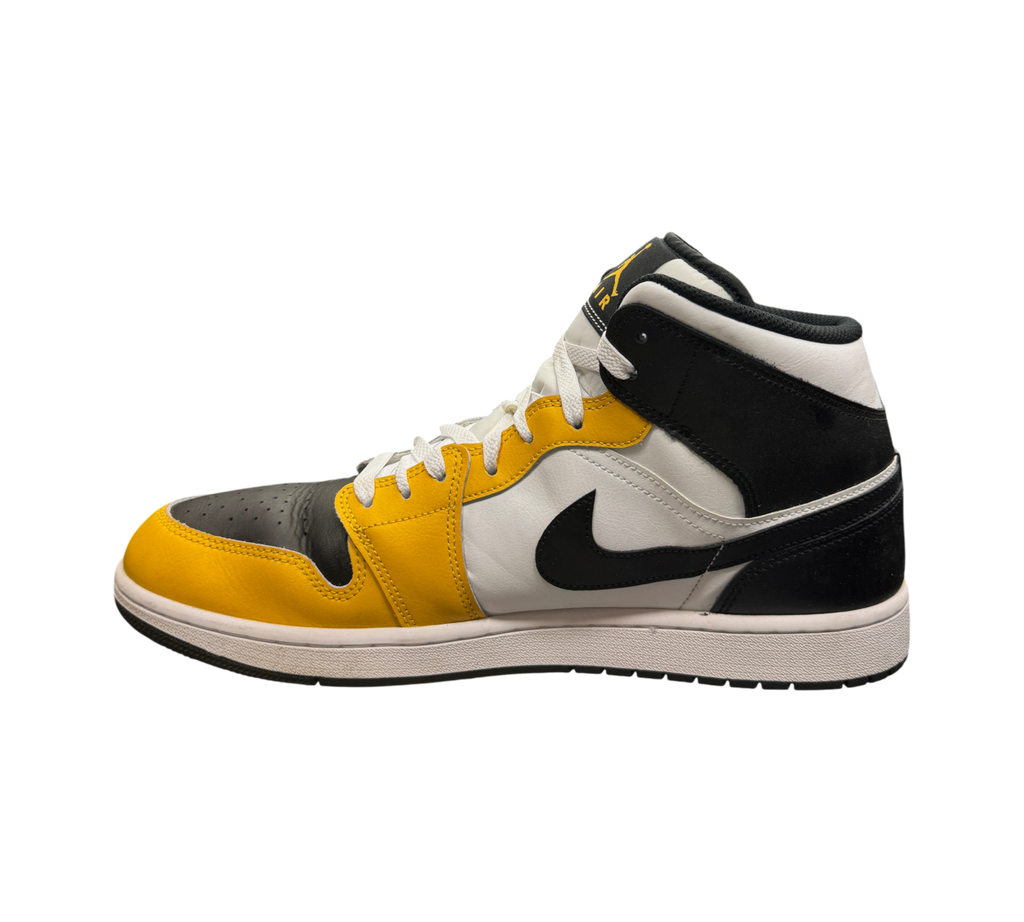 Genesis Boutique Jordan 1 Mid Yellow Ochre sneakers in black, white, and yellow leather on a glass display table.