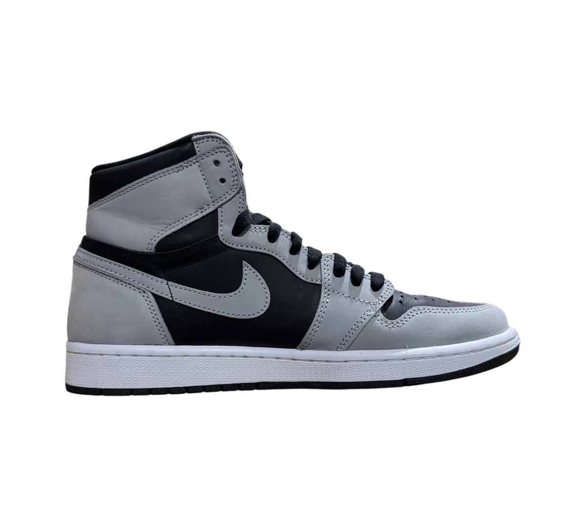 Genesis Boutique Jordan 1 Shadow 2.0 sneakers in black and grey leather, side profile view on a cardboard box.