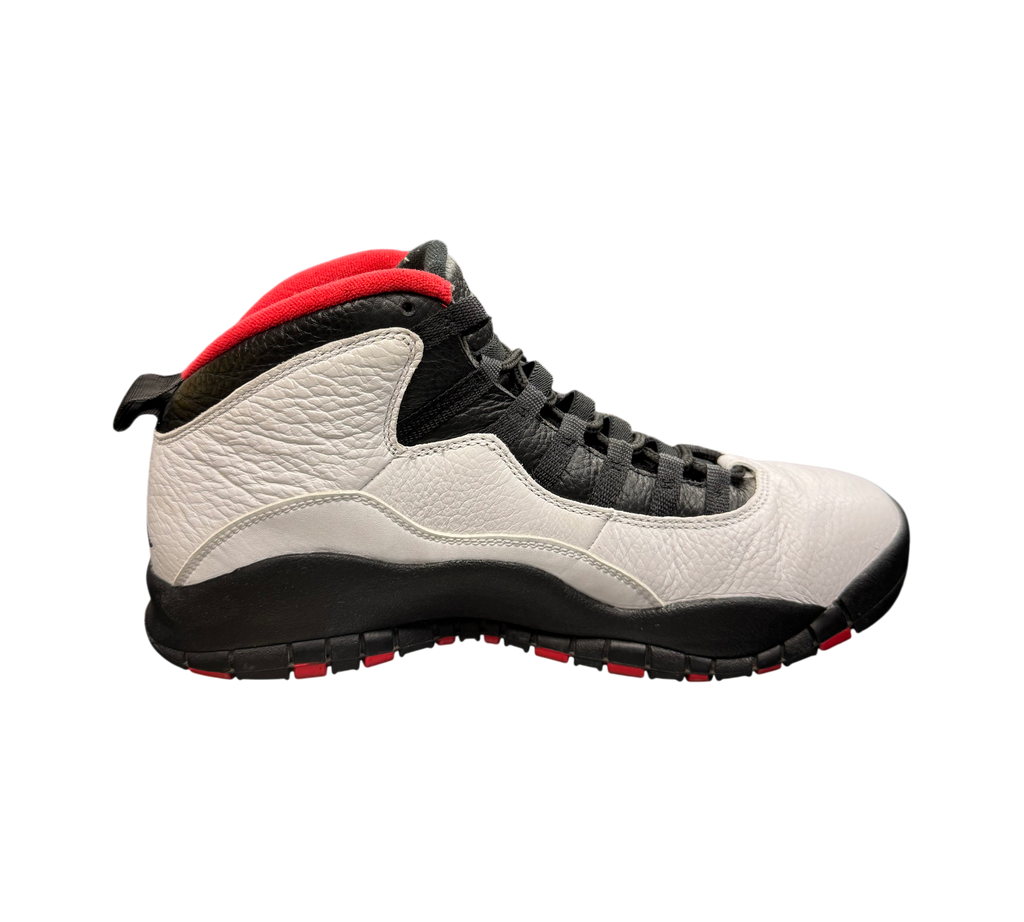 Genesis Boutique Jordan 10 Double Nickel sneakers in white, black, and red leather on a store display counter.
