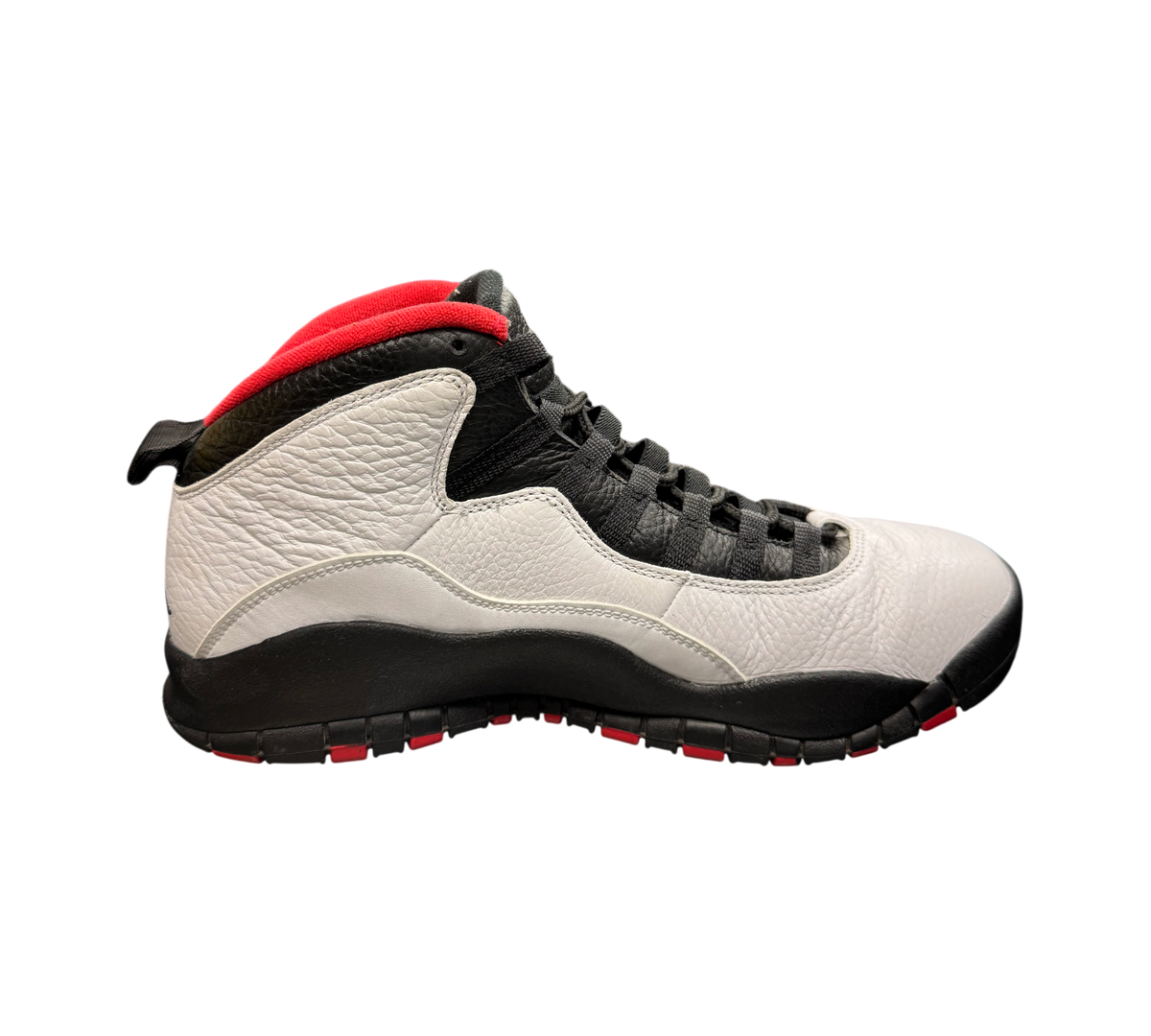 Genesis Boutique Jordan 10 Double Nickel sneakers in white, black, and red leather on a store display counter.