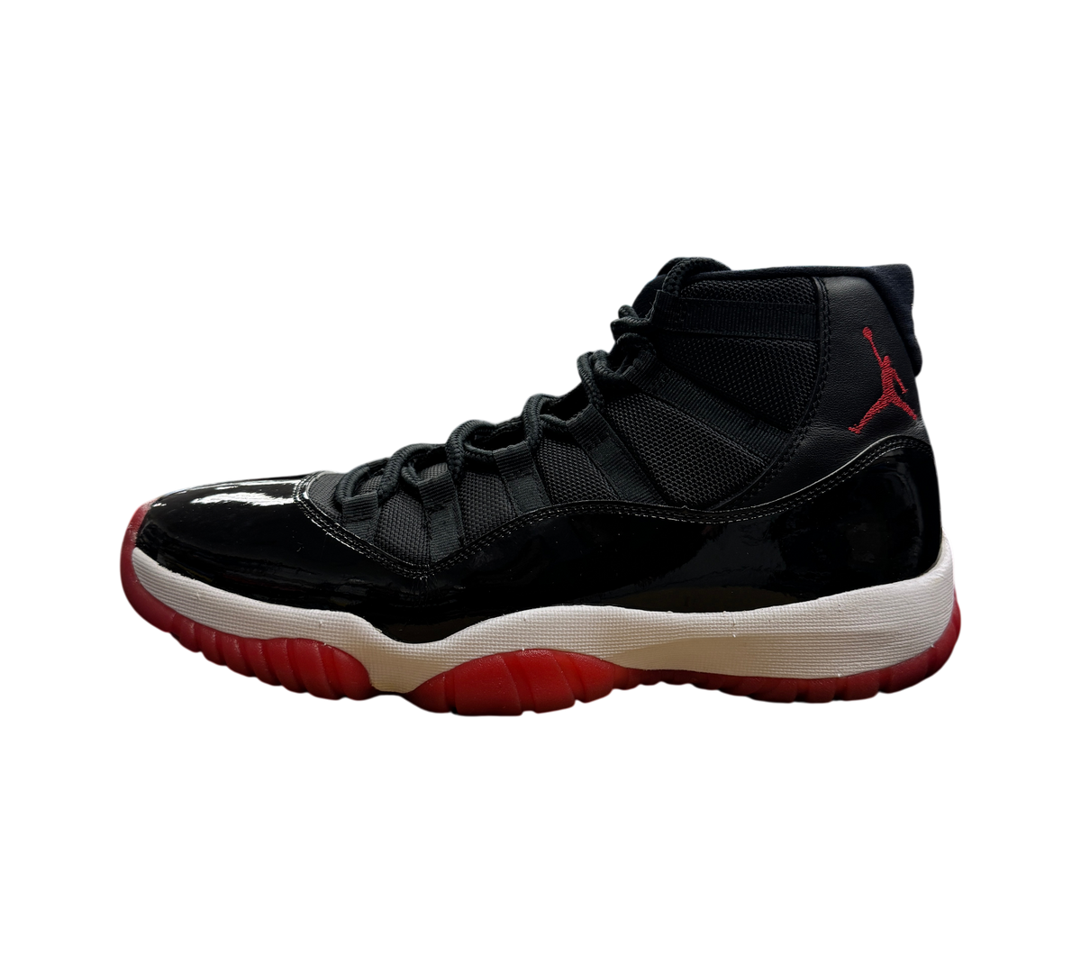Genesis Boutique pre-owned Jordan 11 Bred 2019 sneakers featuring black patent leather, mesh upper, and red outsole.