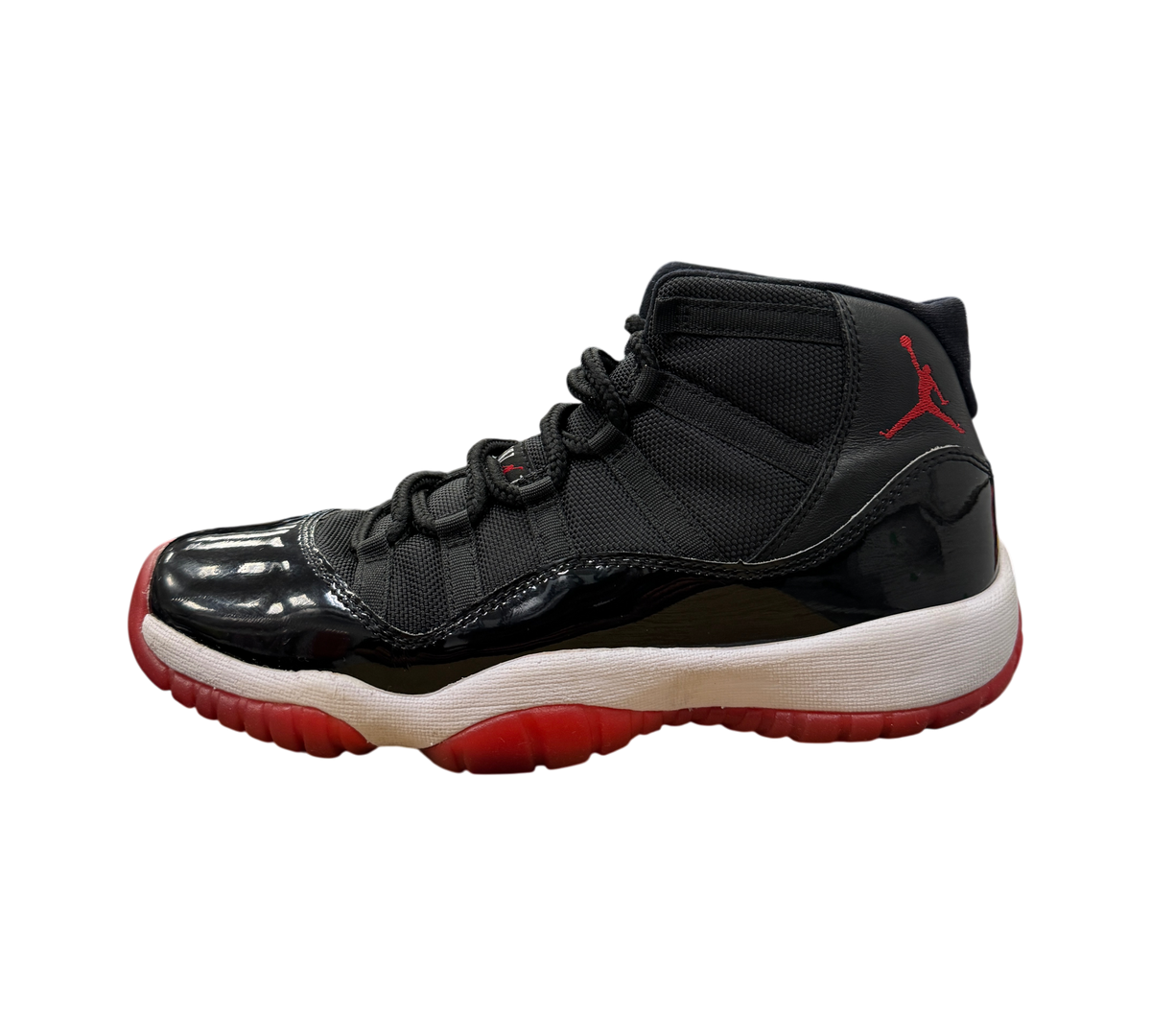 Genesis Boutique Jordan 11 GS Bred sneaker in black patent leather and mesh with a red outsole and Jumpman logo