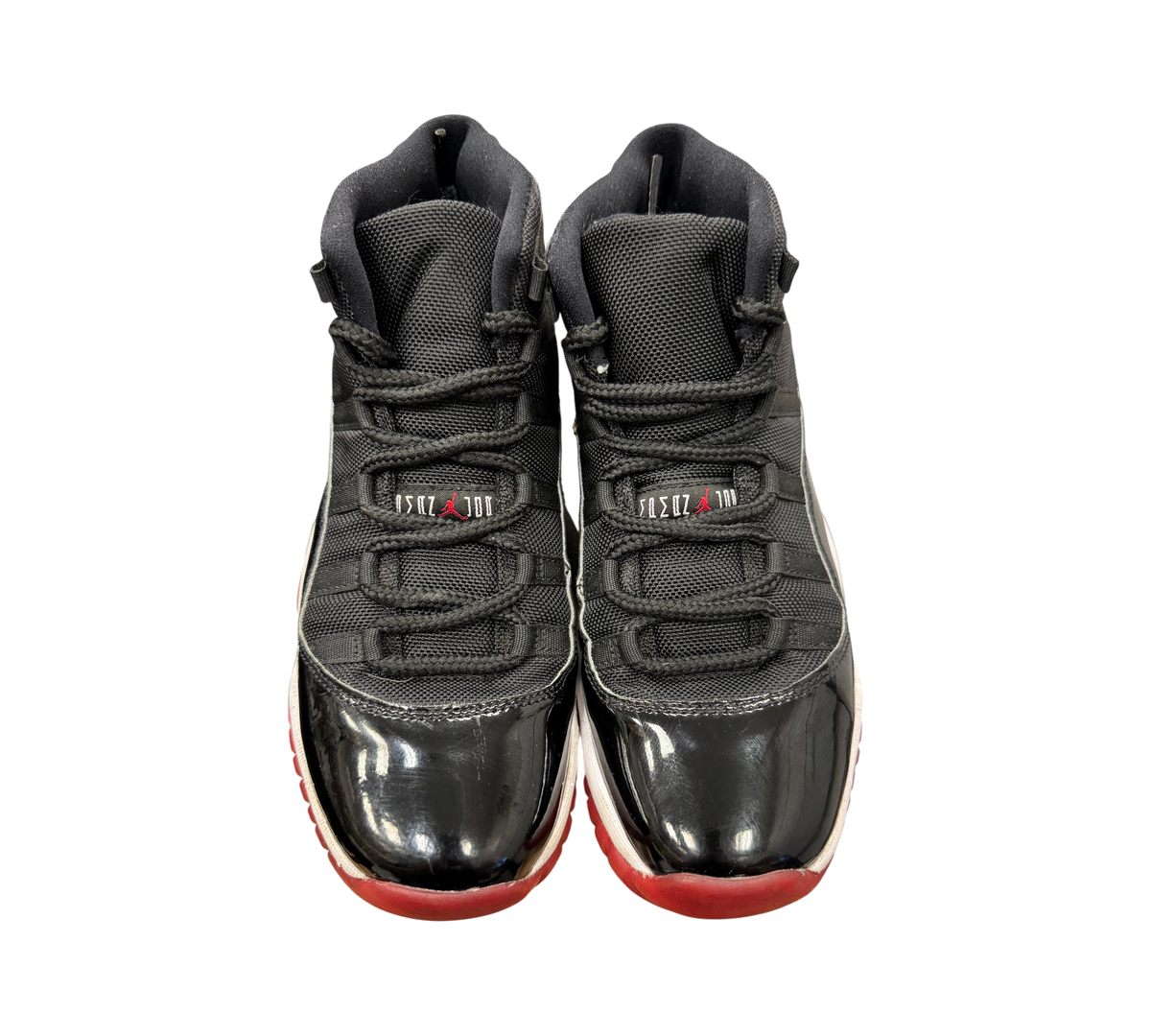 Genesis Boutique Jordan 11 GS Bred sneakers featuring black mesh, patent leather, and a red outsole.