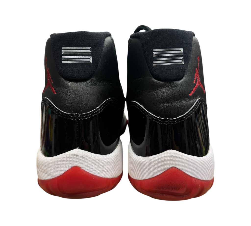 Genesis Boutique Jordan 11 Bred 2019 sneakers showing black patent leather heels and red Jumpman logos