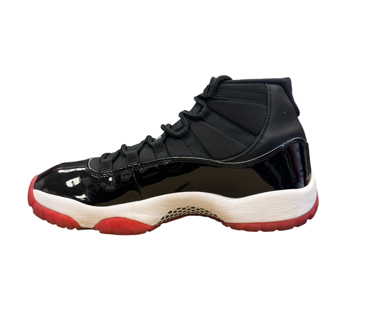 Genesis Boutique used Jordan 11 Bred 2019 sneakers featuring black patent leather, mesh upper, and red outsole.