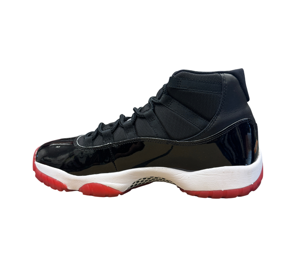 Genesis Boutique Jordan 11 Bred sneaker in black patent leather and mesh with a white midsole and red translucent outsole