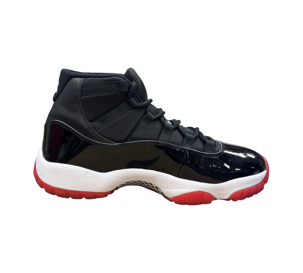 Genesis Boutique Jordan 11 Bred sneaker in black patent leather and mesh with a white midsole and red outsole