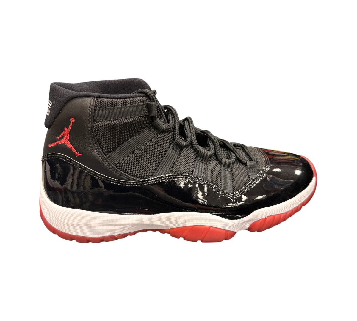 Genesis Boutique Jordan 11 2019 Bred sneakers with black patent leather, red accents, and white midsole.