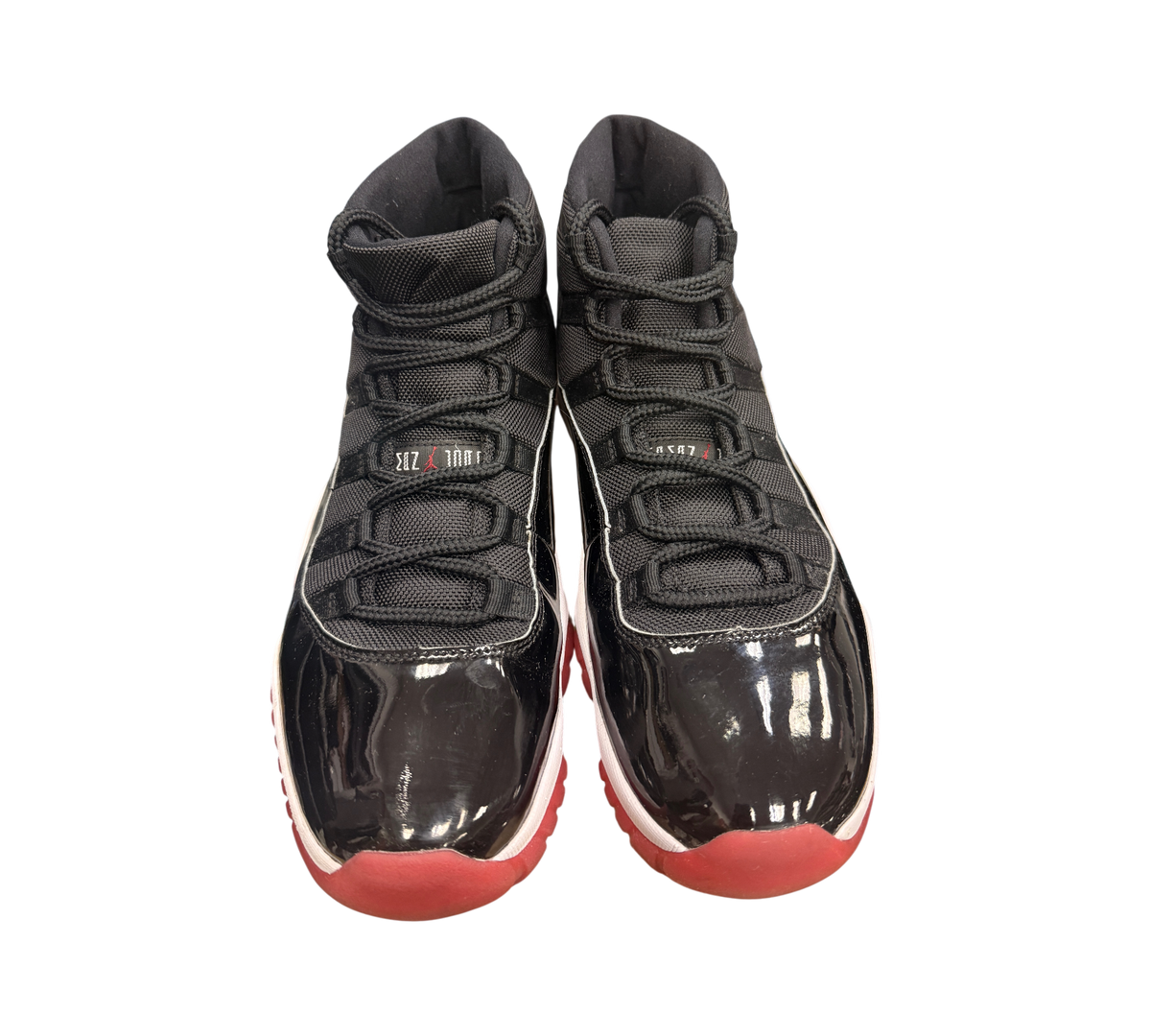 Genesis Boutique USED Jordan 11 2019 Bred sneakers with black patent leather, red soles, and white accents.