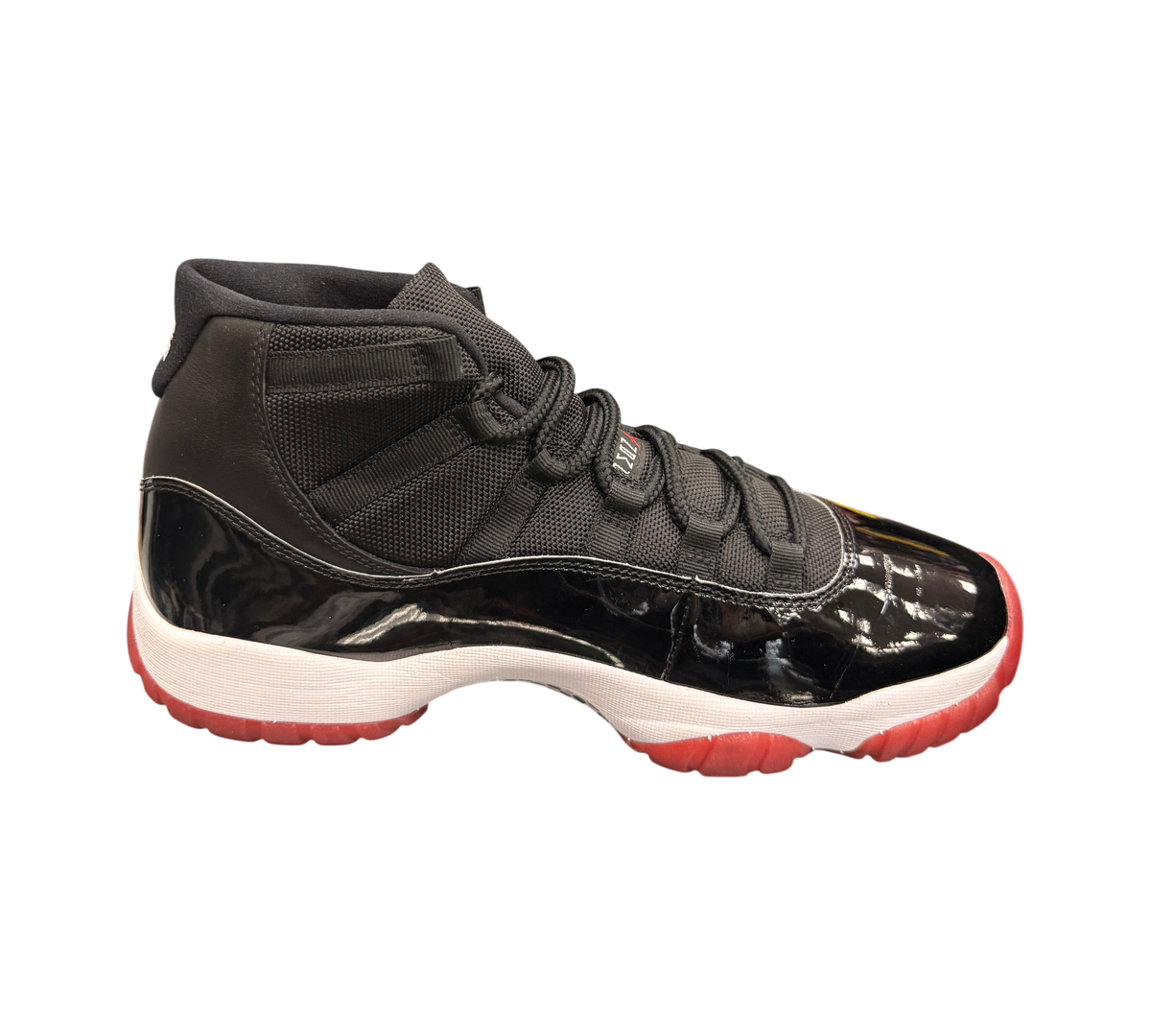 Genesis Boutique Jordan 11 2019 Bred sneakers with black patent leather, red outsole, and white midsole.