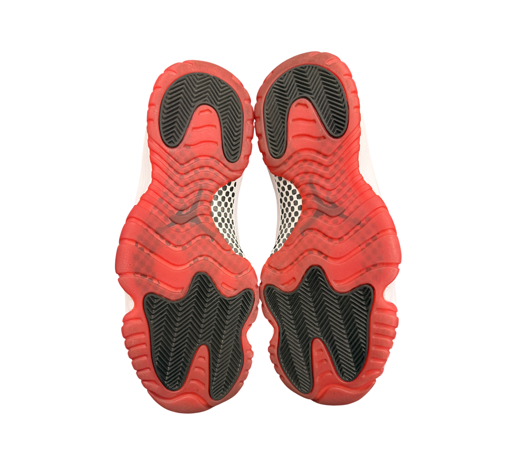 Genesis Boutique Jordan 11 2019 Bred sneakers feature red and black rubber soles with white accents.