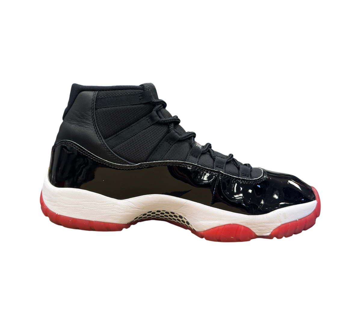 Genesis Boutique used Jordan 11 Bred 2019 sneakers featuring black patent leather and a red translucent outsole.