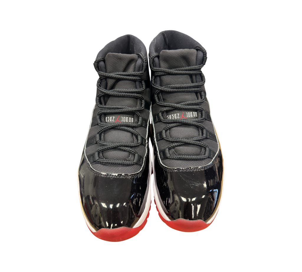 Genesis Boutique used Jordan 11 Bred 2019 sneakers featuring black patent leather, mesh upper, and red outsole.