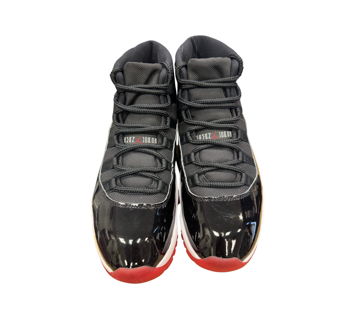 Genesis Boutique used Jordan 11 Bred 2019 sneakers featuring black patent leather, mesh upper, and red outsole.