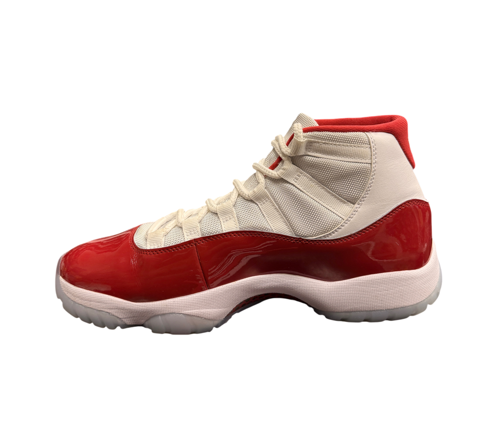 Genesis Boutique Jordan 11 Cherry sneakers featuring white mesh, red patent leather mudguard, and translucent outsole.