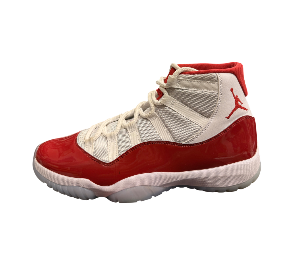Genesis Boutique pre-owned Jordan 11 Cherry sneakers featuring white mesh, red patent leather, and a translucent sole.