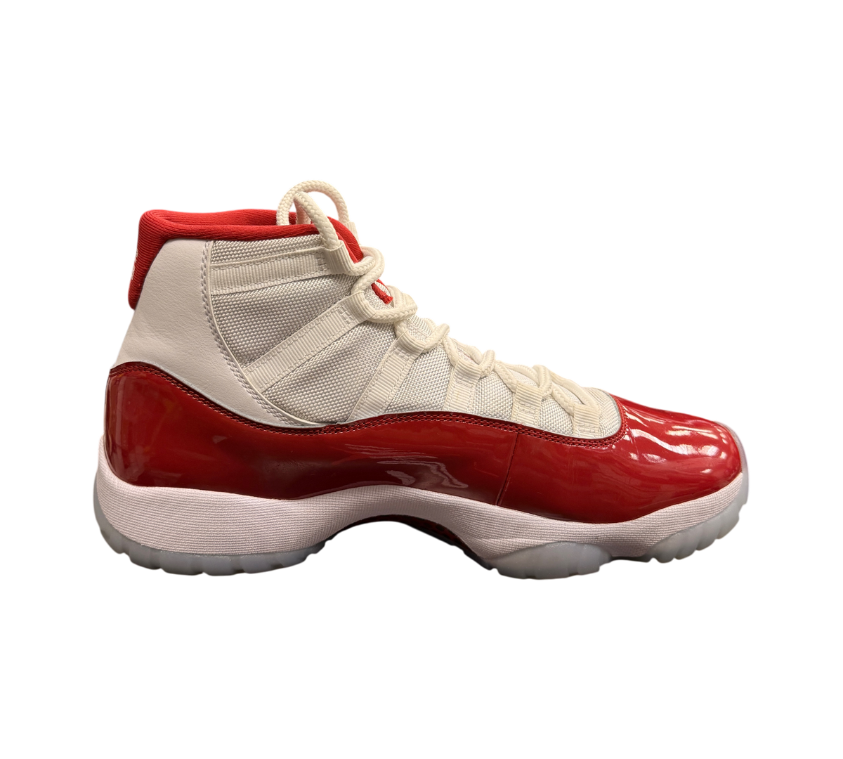 Genesis Boutique pre-owned Jordan 11 Cherry sneakers featuring white mesh, red patent leather, and translucent soles.