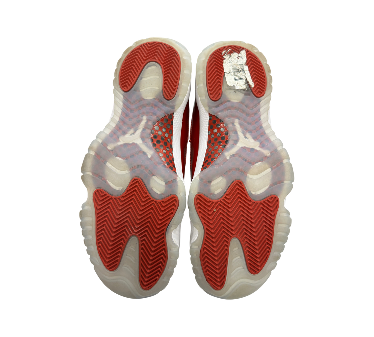 Genesis Boutique used Jordan 11 Cherry sneakers showing red and translucent rubber outsoles with herringbone pattern