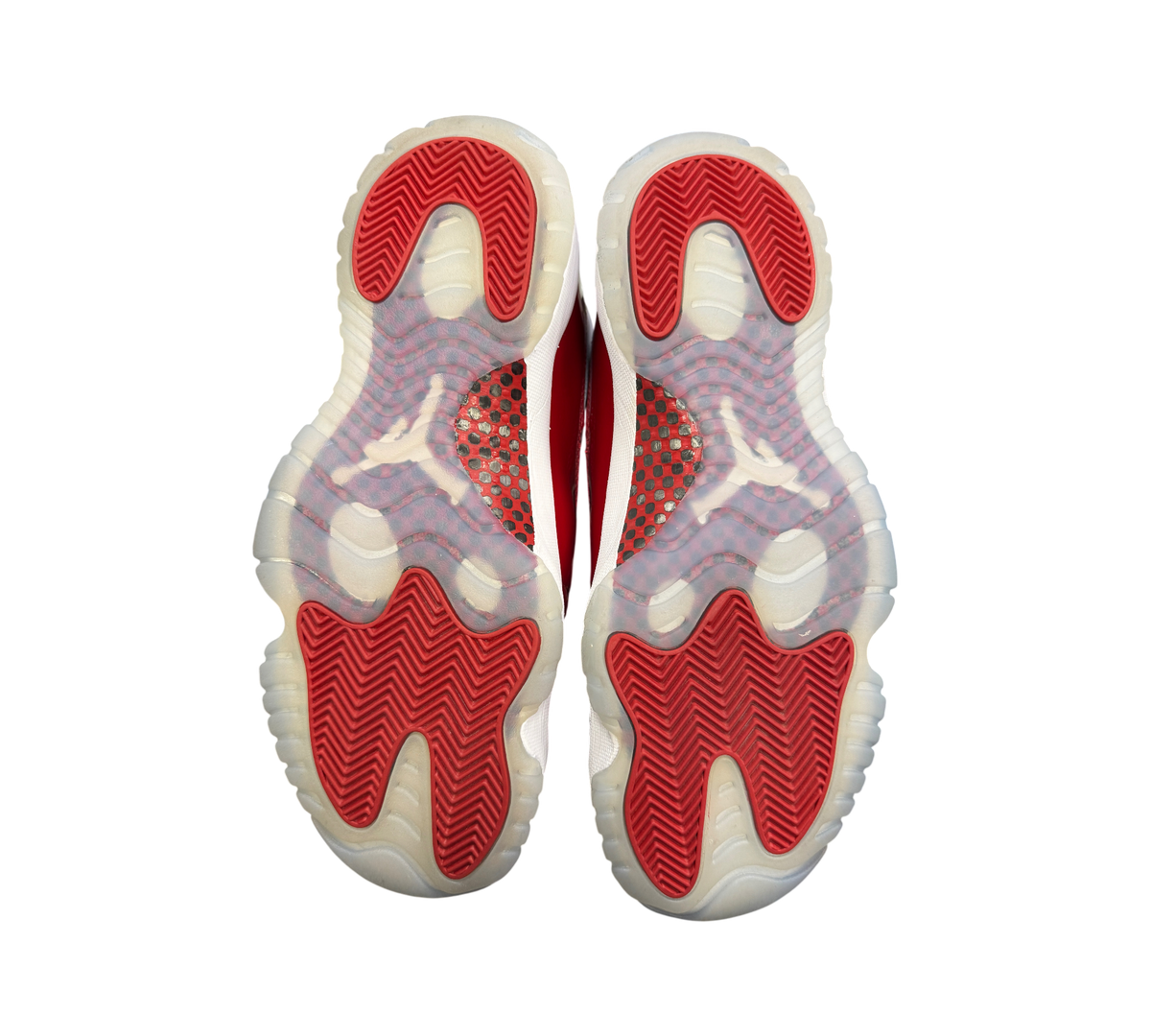 Genesis Boutique Jordan 11 Cherry sneakers showing red and white translucent outsoles with carbon fiber plate detail
