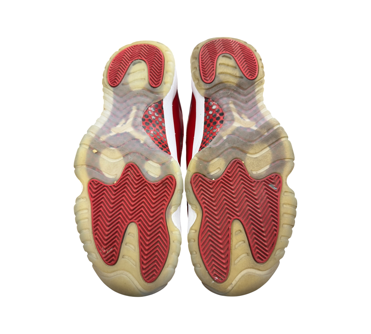 Genesis Boutique used Jordan 11 Cherry sneakers showing red and translucent rubber outsoles with herringbone pattern