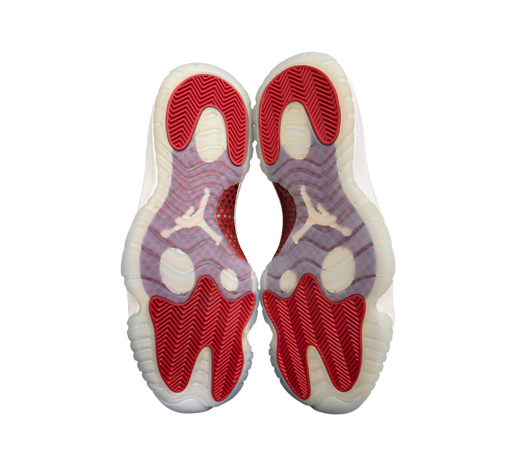Genesis Boutique Jordan 11 Cherry sneakers showing the red and translucent white herringbone traction outsoles