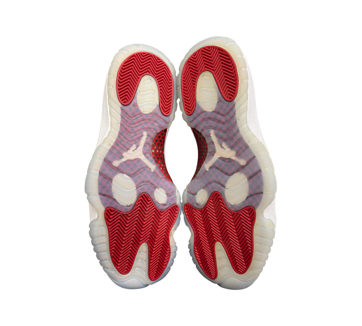 Genesis Boutique Jordan 11 Cherry sneakers showing the red and translucent white herringbone traction outsoles