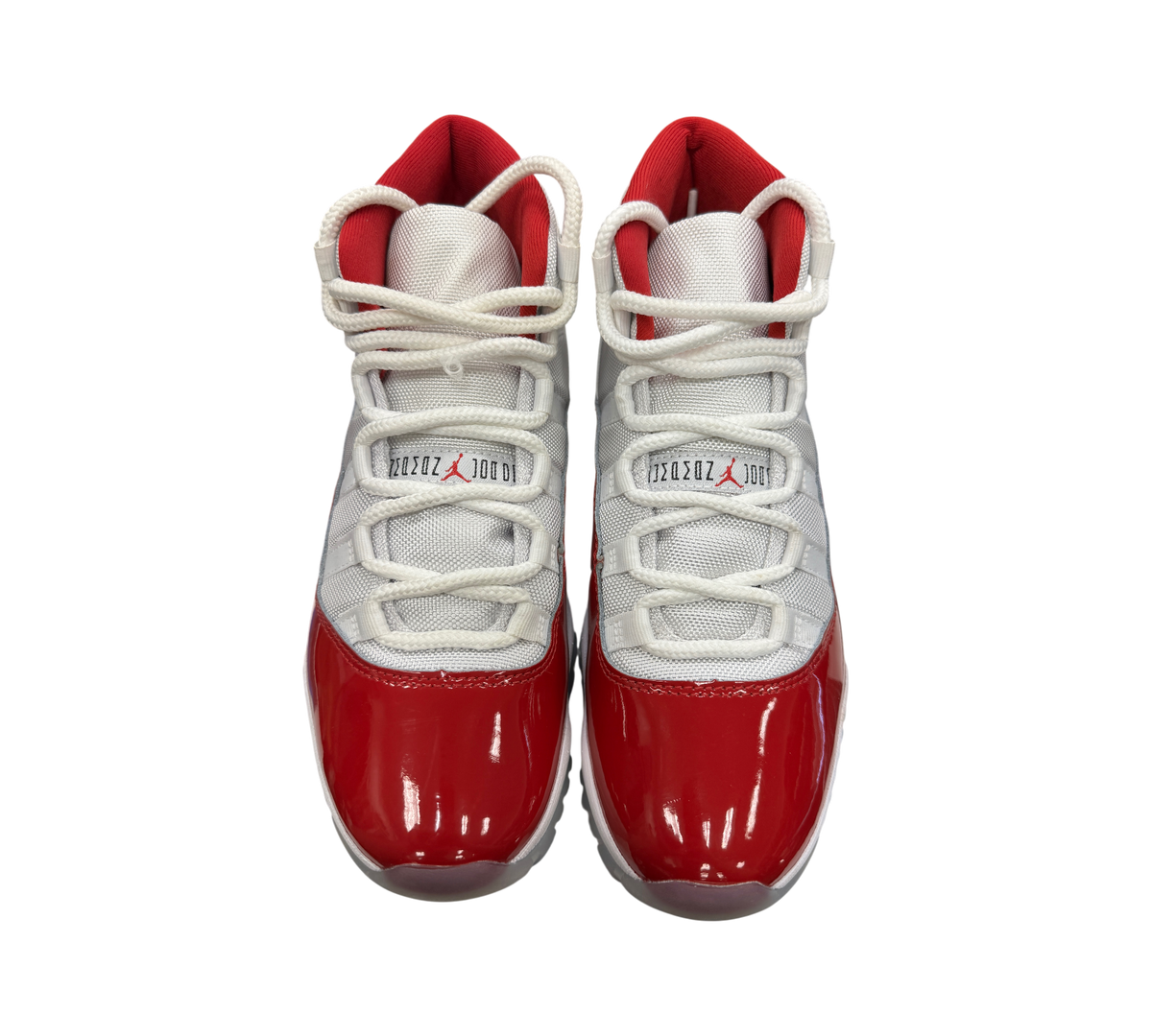 Genesis Boutique Jordan 11 Cherry sneakers with white mesh upper, red patent leather mudguard, and red inner lining.