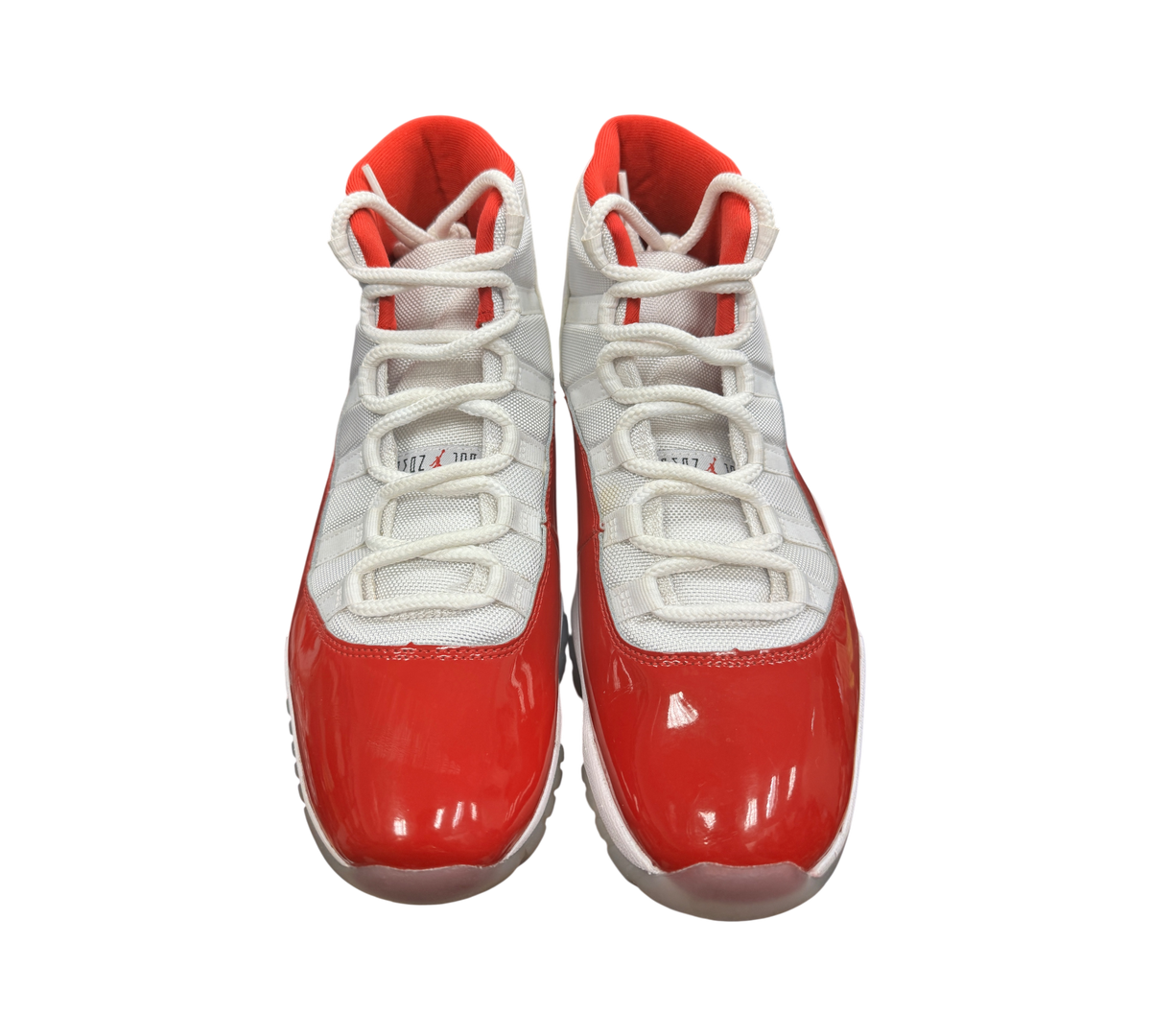 Genesis Boutique Jordan 11 Cherry sneakers featuring white mesh uppers and glossy red patent leather mudguards