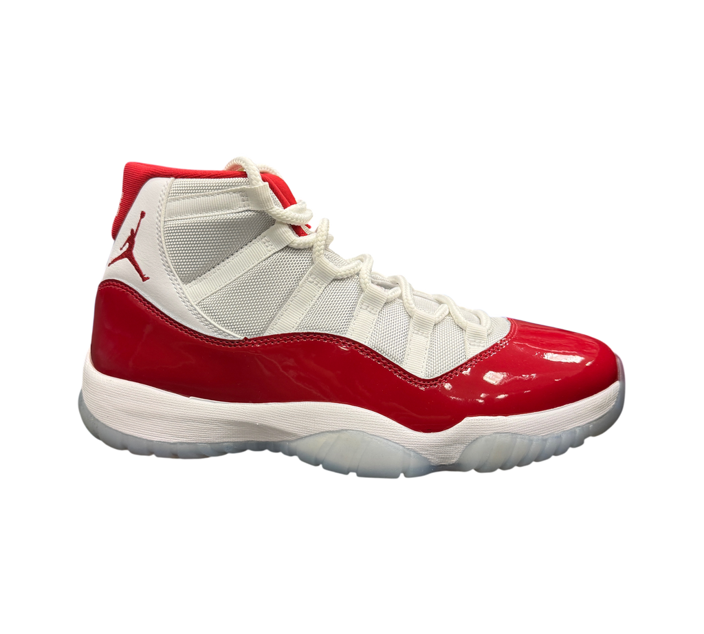 Genesis Boutique Jordan 11 Cherry sneakers featuring white mesh upper, red patent leather mudguard, and icy outsole.
