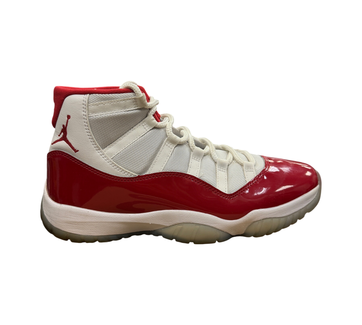 Genesis Boutique Jordan 11 Cherry sneakers featuring white mesh, red patent leather mudguard, and Jumpman logo.